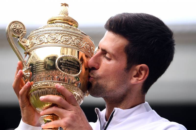 Novak Djokovic mencium tropi Wimbledon atas kemenangannya di tahun 2019
